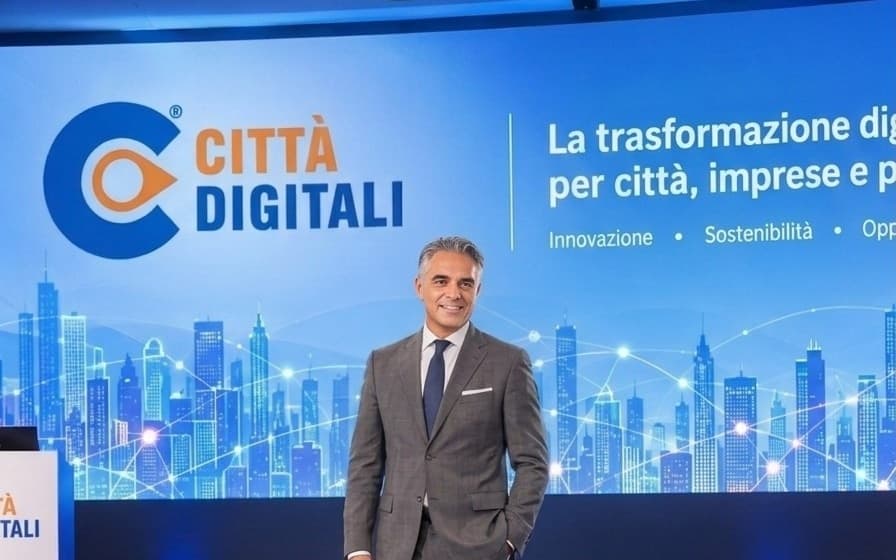 Giacomo Lenoci sul palco, davanti allo schermo con il marchio Città Digitali.