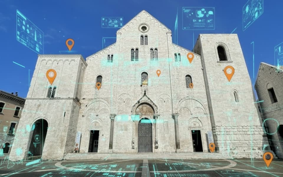 La facciata in pietra chiara di una chiesa tra due torri; sopra, segnaposto arancioni, pannelli digitali azzurri e linee luminose sulla piazza.